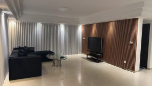 a room with a couch and a television עיצוב סלון מודרני - טקי דיזיין